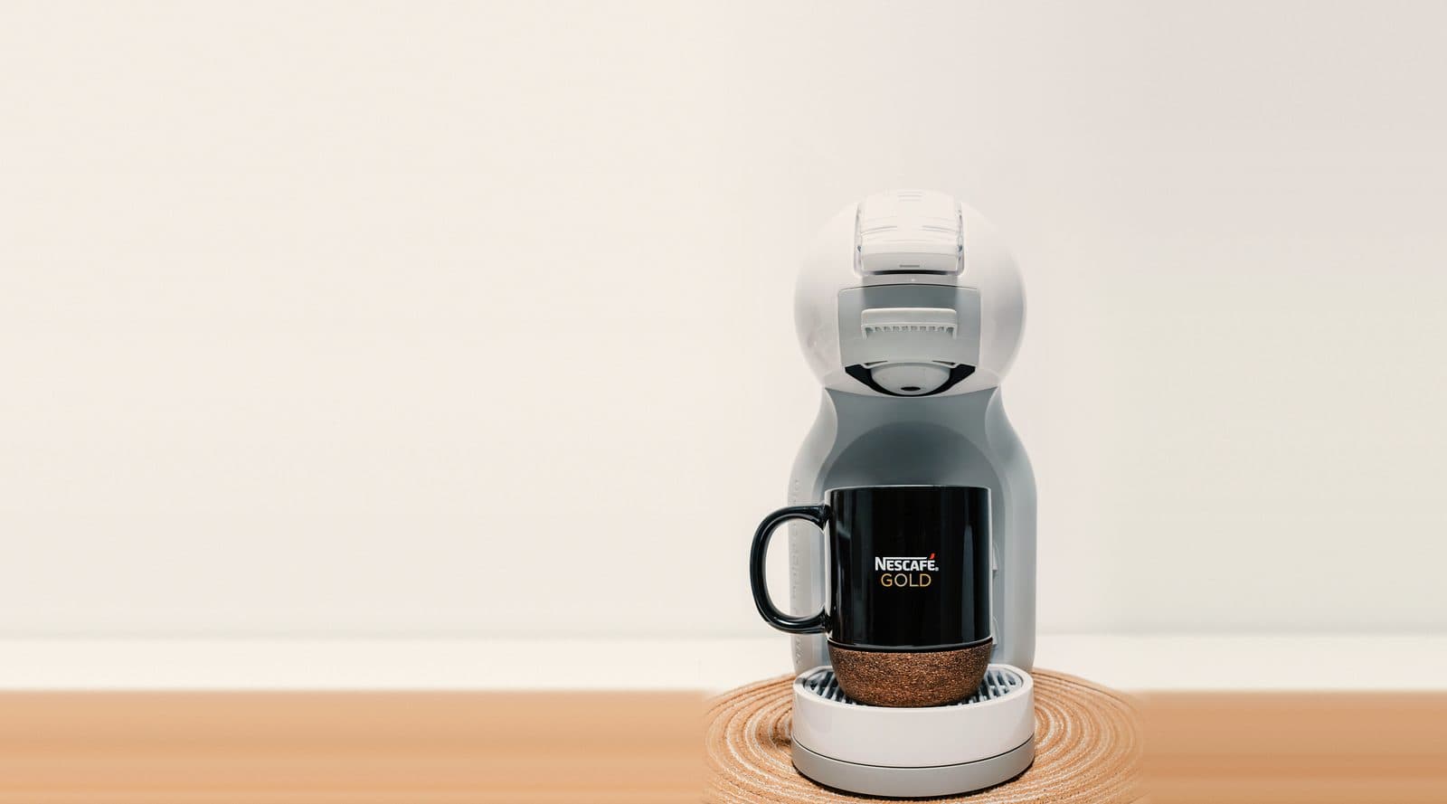 Witte Dolce Gusto Mini Me met een zwarte mok onder de uitloop