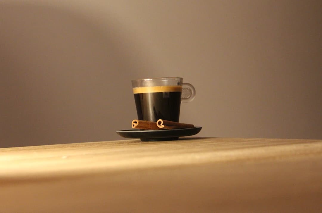Koffiecapsules naast verse koffiebonen op een houten tafel