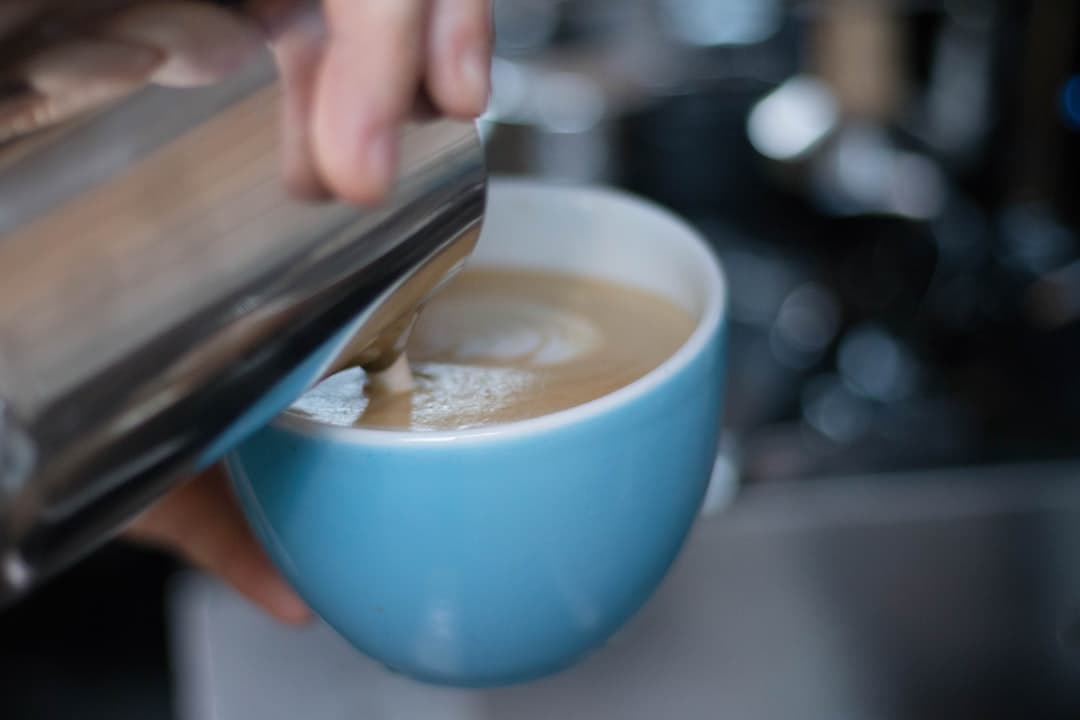 Flat white met latte art in een wit kopje op een houten tafel