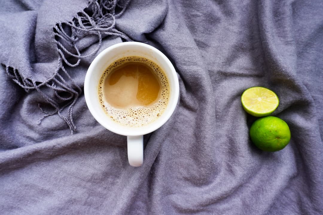 Kopje zwarte koffie naast sportschoenen en een weegschaal