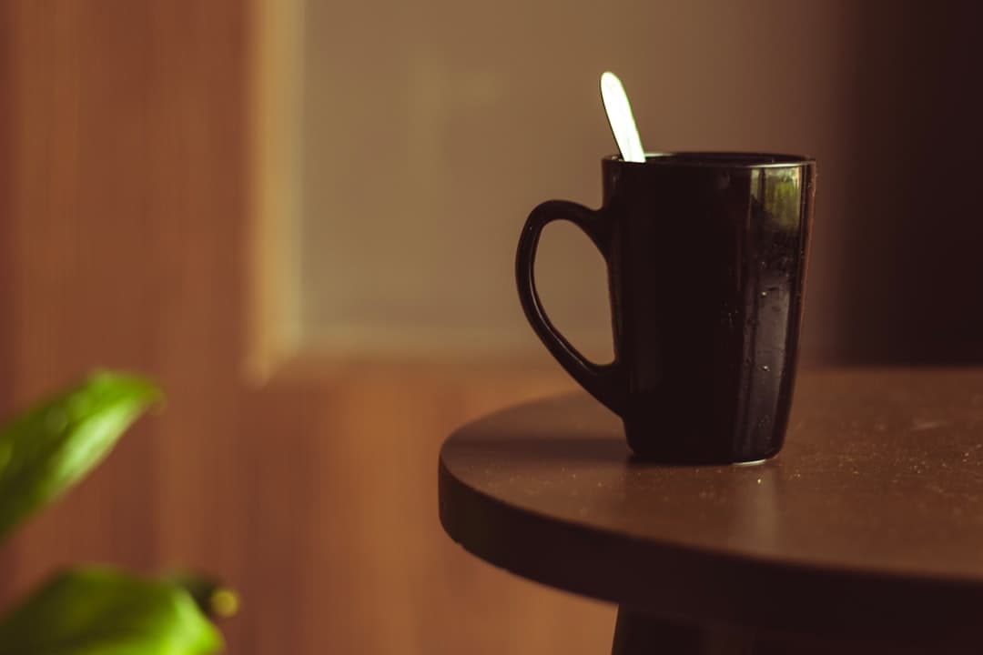Kopje zwarte koffie op een houten tafel naast verse koffiebonen