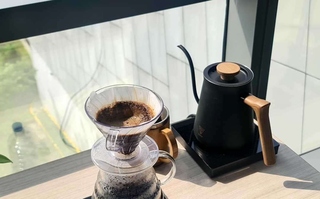 Koffie zetten met een waterketel naast een raam met ochtendlicht