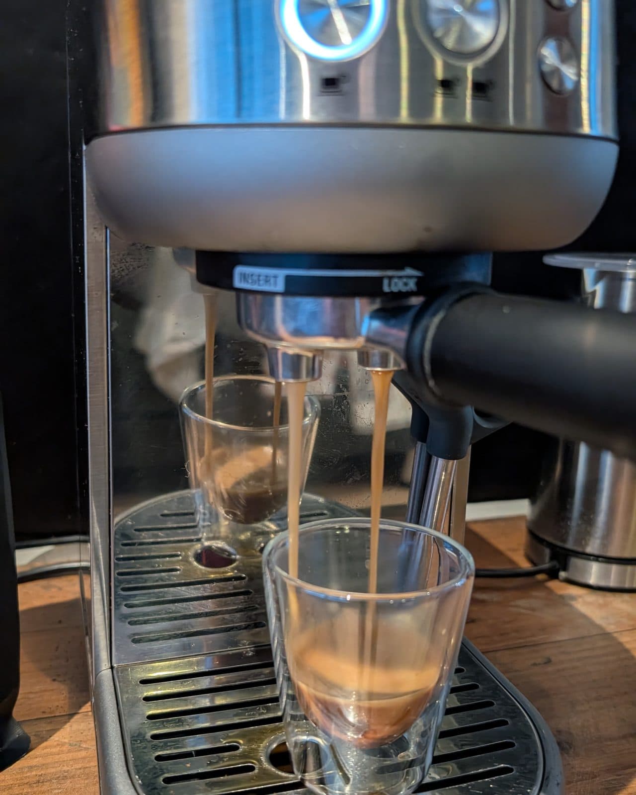 Espresso loopt in twee straaltjes uit de Sage Bambino in een dubbelwandig glas