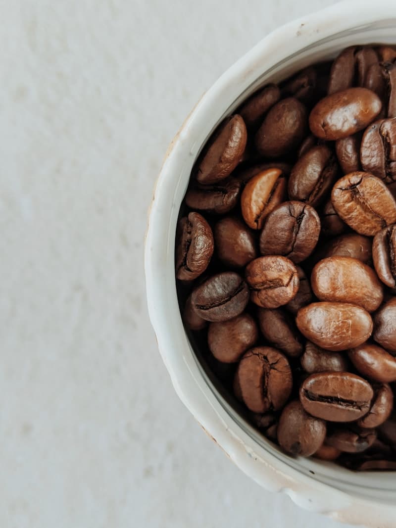 Filterkoffie wordt geschonken uit een glazen kan in een witte mok