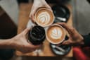 Dampende kop fairtrade koffie met bonen op de achtergrond