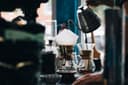 Dampende kop filterkoffie op houten tafel met koffiebonen ernaast