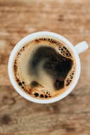 Donker gebrande espressobonen in een houten schep, close-up