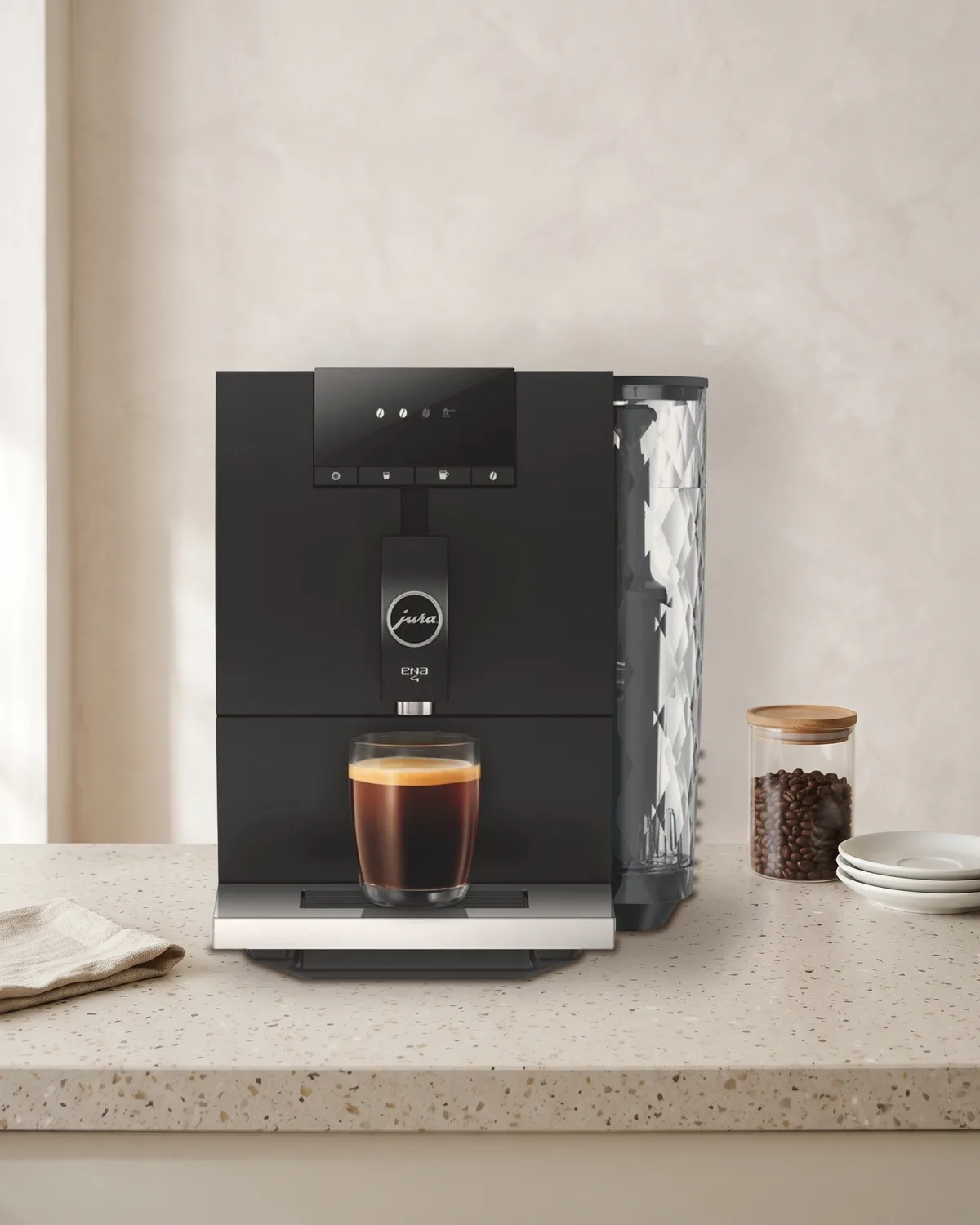 JURA ENA 4 Full Metropolitan Black volautomaat op een terrazzo aanrecht tegen een lichte kalkverfmuur
