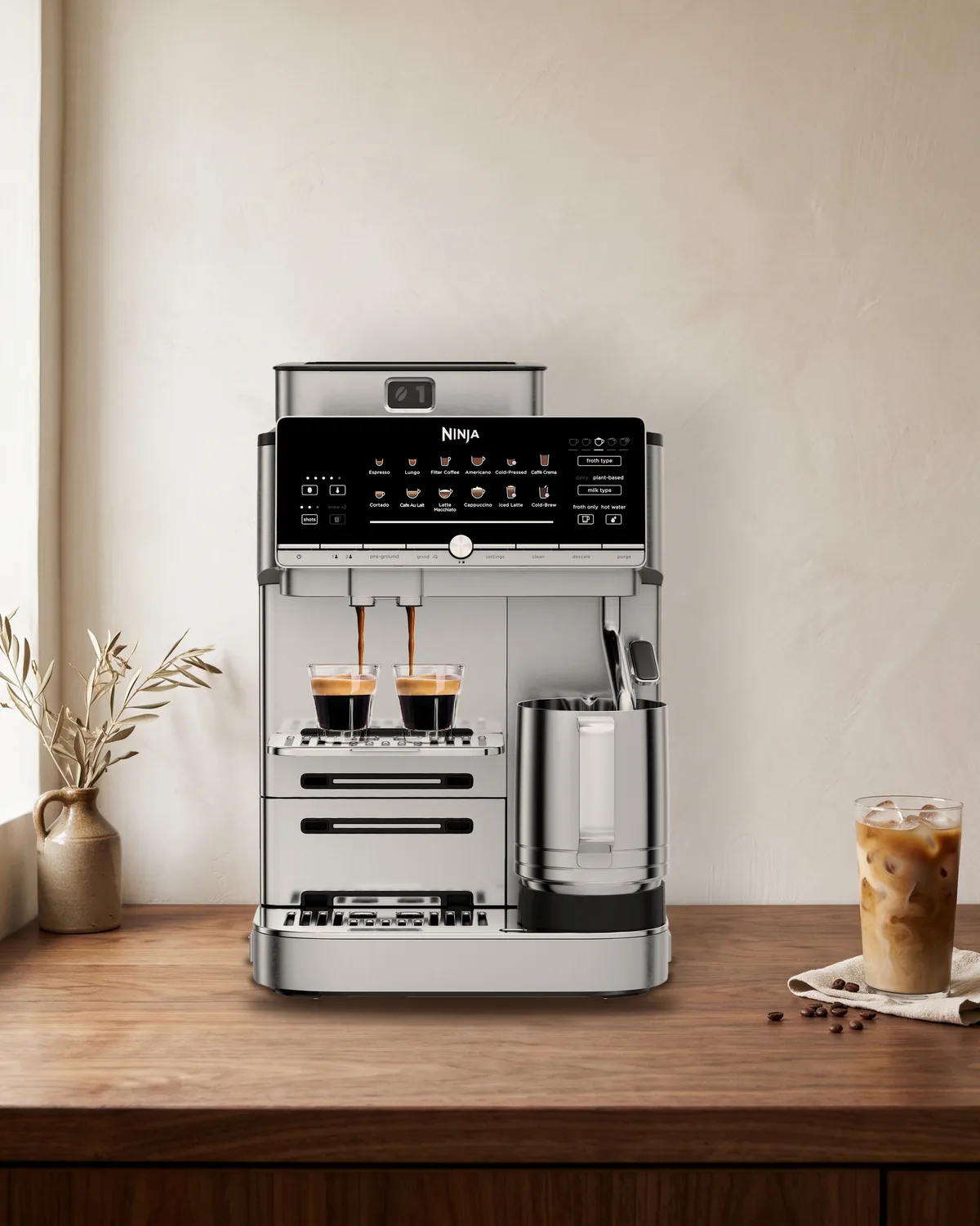 Ninja AutoBarista Pro volautomaat in roestvrij staal op een notenhouten aanrecht tegen een lichte gestucte muur
